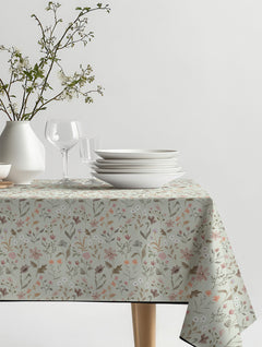 Mantel de hule Blotchys con flores silvestres pequeñas en rosado, terracota y verde salvia, sobre una mesa de comedor