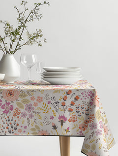Mantel de hule Dreamed 03 con flores ilustradas en rosado, coral y mostaza, sobre una mesa de comedor