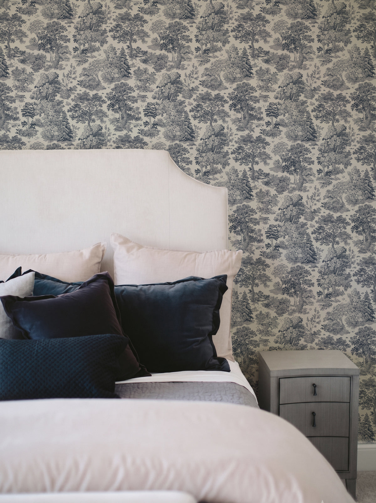 Papel mural Moulin Blue, clásico diseño de toile de Jouy azul sobre crema con bosques y pinos a plumilla.