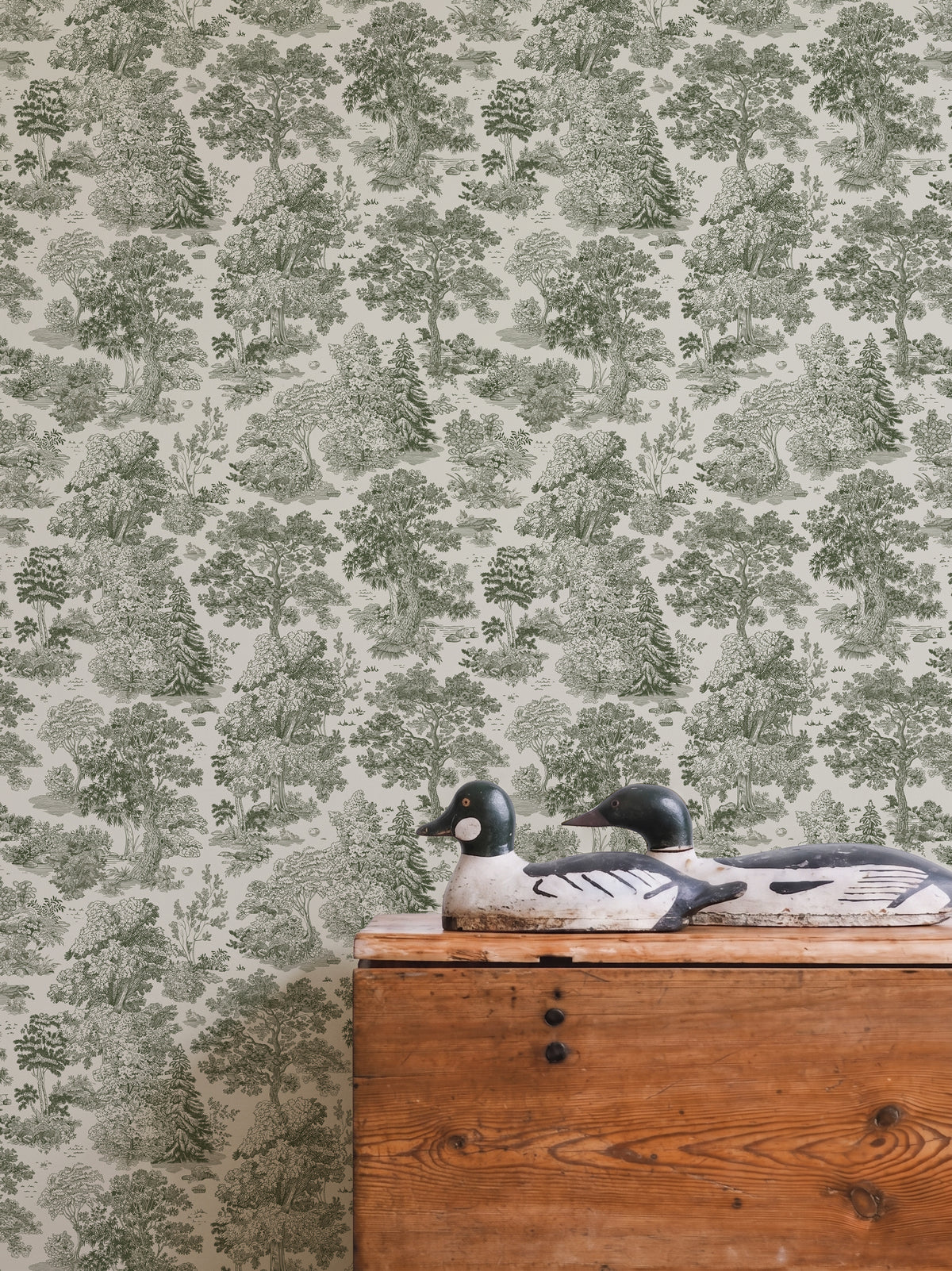 Papel mural Moulin Green, sereno diseño de toile verde salvia sobre crema con bosques y pinos a plumilla.