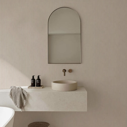 Papel mural Ram Smoky Brown, cálido diseño de rayas verticales finas en beige arena y blanco crudo. Ideal para baños y cocinas.