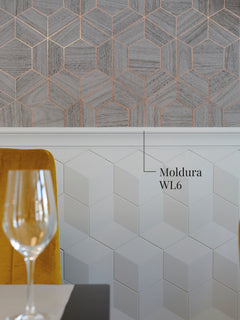 Moldura muro WL6 como remate de un zócalo de paneles blancos bajo un papel mural geométrico