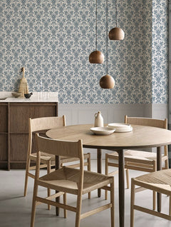Papel mural Ellie Blue en un ambiente decorado: patrón botánico denso en azul acero.