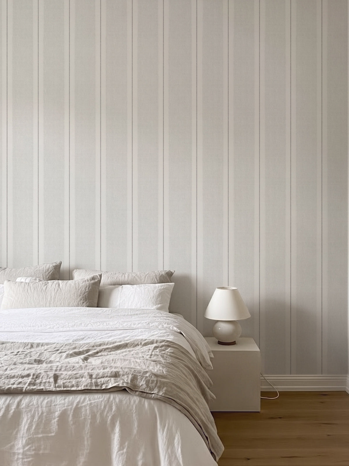 Papel mural Henry White, sobrio diseño de rayas verticales de distinto ancho en blanco y gris perla. Ideal para baños y cocinas.