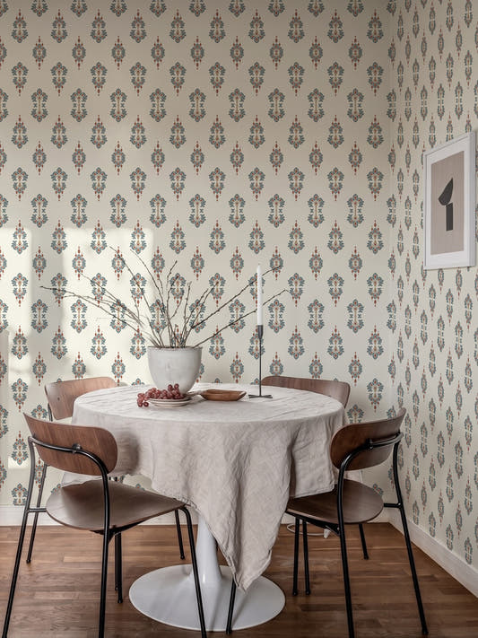 Papel mural Ikat Outpoint, sofisticado diseño de medallones romboidales en azul grisáceo y terracota sobre crema. Ideal para baños y cocinas.
