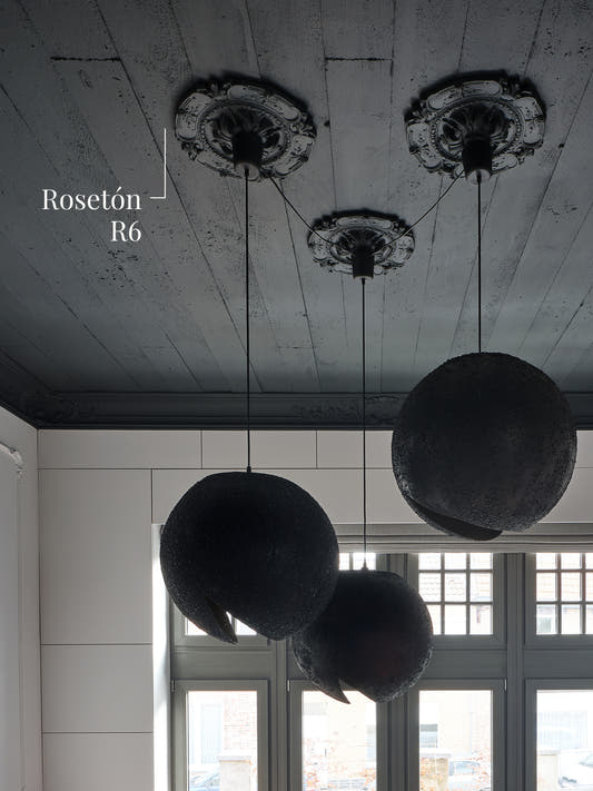Rosetón R6 en un cielo oscuro, con una lámpara colgante en cada uno de los tres rosetones